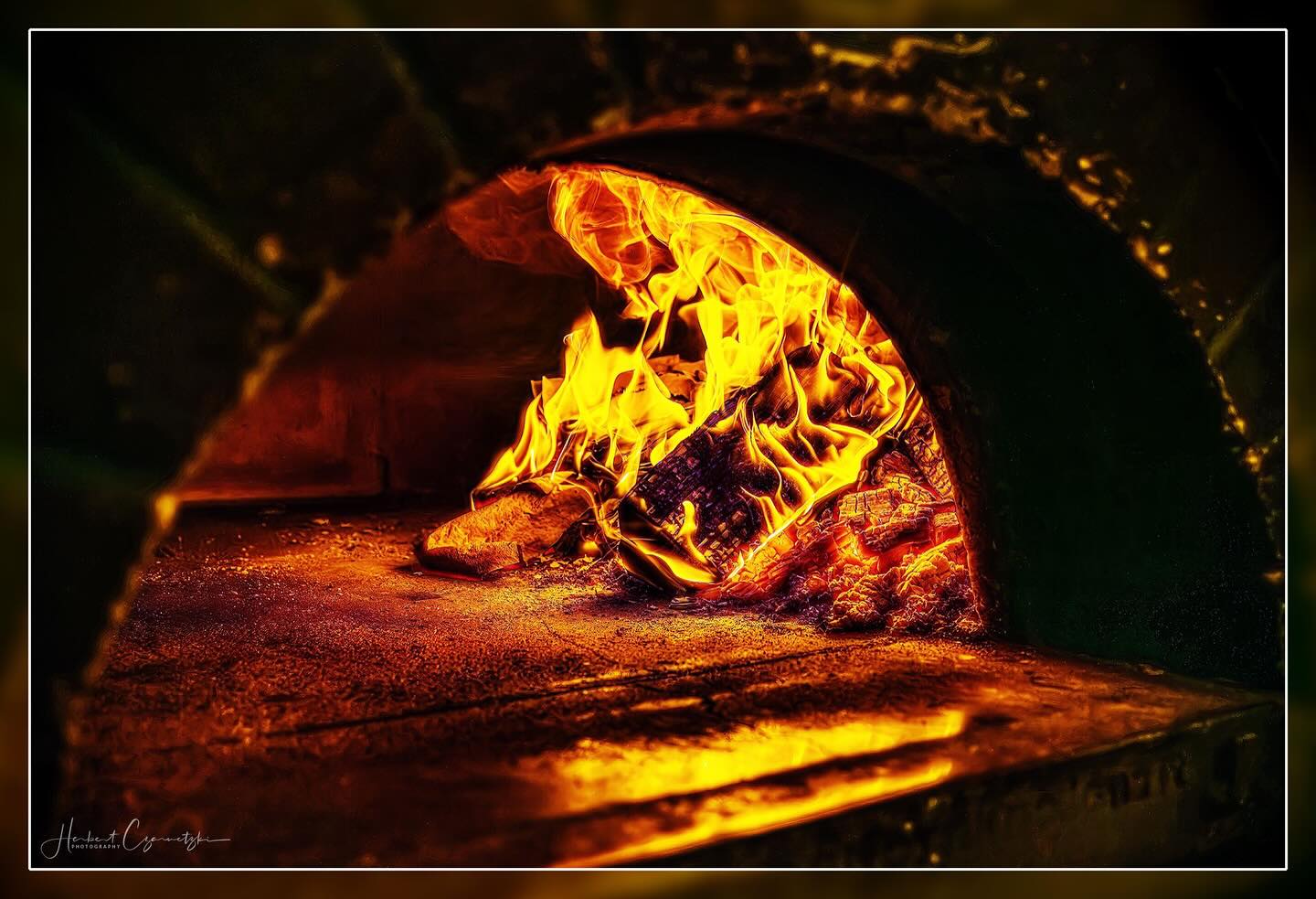 Pizzaiolo am Holzofen der Pizzeria La Famiglia